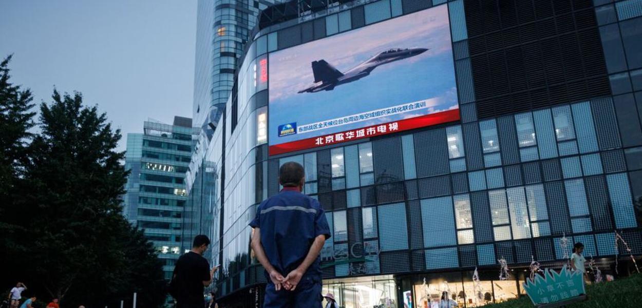 Exercícios militares são transmitidos em telão em um shopping center em Pequim
