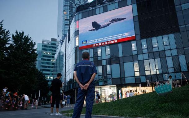 Exercícios militares são transmitidos em telão em um shopping center em Pequim