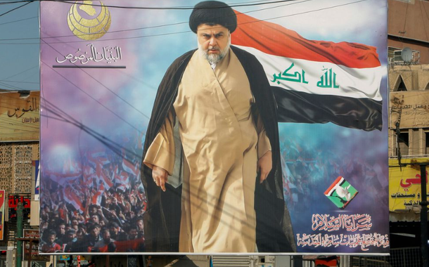 Um pôster do clérigo xiita iraquiano Moqtada al-Sadr no distrito de Sadr City, em Bagdá, Iraque, 21 de junho de 2021. O texto no canto superior esquerdo do pôster diz 'A estrutura sólida'. O texto no canto inferior direito do pôster diz 'Saraya al-Salam, comando de operação da sagrada Samarra'.