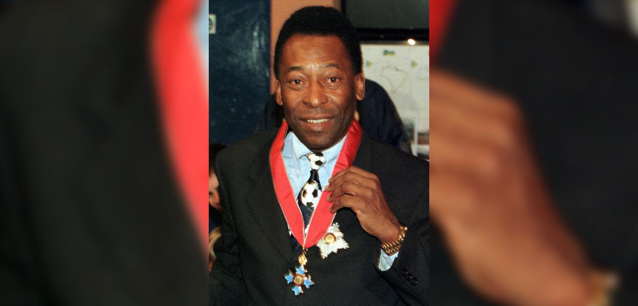 Pelé exibe condecoração recebida da rainha Elizabeth II, em Londres