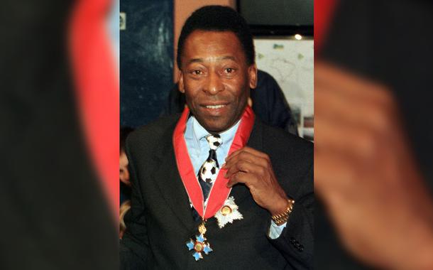 Pelé exibe condecoração recebida da rainha Elizabeth II, em Londres