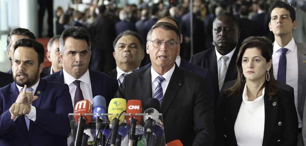 Jair Bolsonaro, acompanhado de vários ministros, fala com a imprensa no Palácio da Alvorada