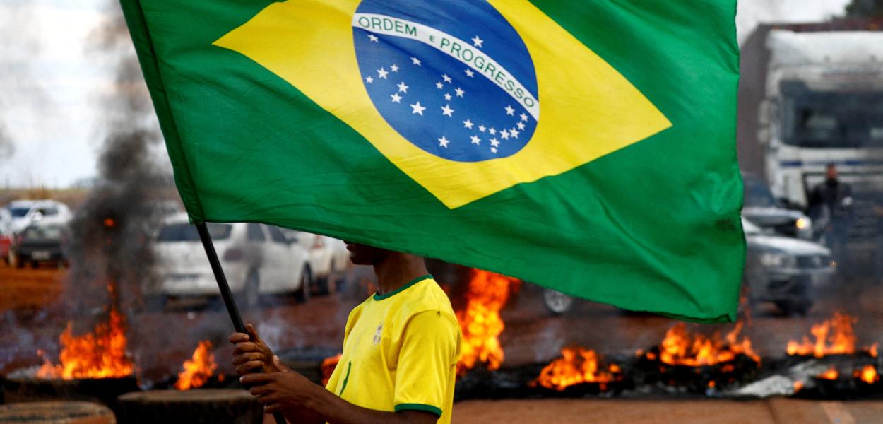 Homem segura bandeira brasileira durante bloqueio na BR-251 em Planaltina 31/10/2022