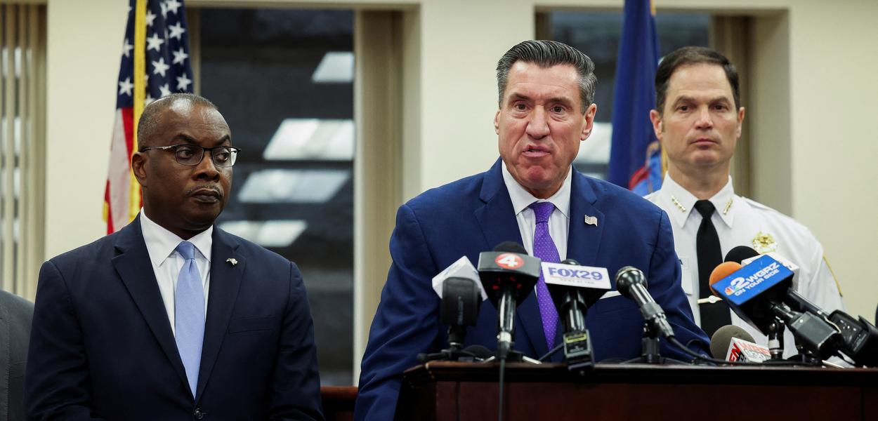 John Flynn, promotor distrital do condado de Erie, fala à mídia ao lado do prefeito de Buffalo, Byron Brown, e do comissário de polícia, Joseph Gramaglia, depois que Payton Gendron se declarou culpado