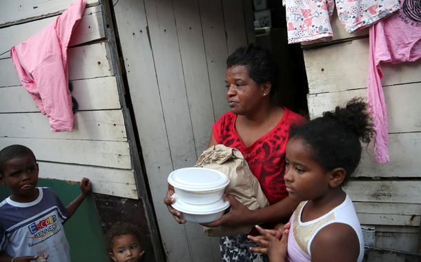 Residentes de uma comunidade no Rio de Janeiro recebem comida de voluntários em 2021