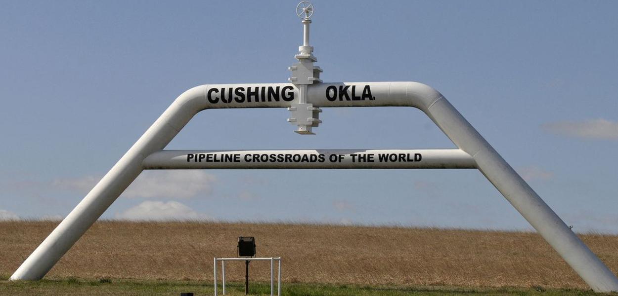 Uma placa construída a partir de um oleoduto que diz "encruzilhada de oleodutos do mundo" dá as boas-vindas aos visitantes da cidade em Cushing, Oklahoma, em 24 de março de 2016