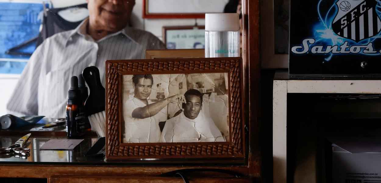 João Araújo, conhecido como Didi, 84 anos, que foi cabeleireiro de Pelé, olha para uma foto sua com o Rei do Futebol - 30/12/2022