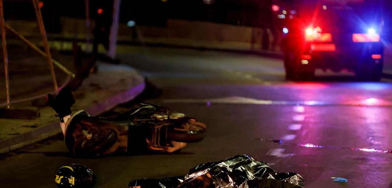 Forças israelenses trabalham ao lado de um corpo coberto no local de um ataque a tiros em Neve Yaacov, que fica em uma terra ocupada que Israel anexou a Jerusalém após a guerra de 1967 no Oriente Médio. 27 de janeiro de 2023