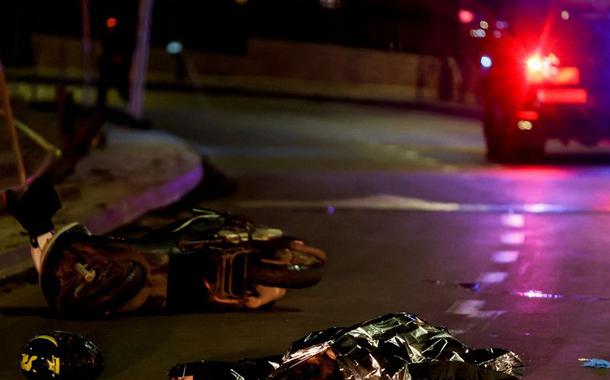 Forças israelenses trabalham ao lado de um corpo coberto no local de um ataque a tiros em Neve Yaacov, que fica em uma terra ocupada que Israel anexou a Jerusalém após a guerra de 1967 no Oriente Médio. 27 de janeiro de 2023