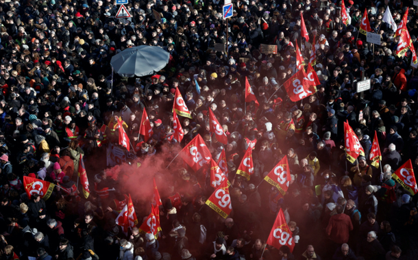 Manifestantes seguram bandeiras sindicais francesas da CGT enquanto se reúnem na Place d'Italie durante uma manifestação contra o plano de reforma previdenciária do governo francês em Paris, como parte de um dia de greve nacional e protestos na França, em 31 de janeiro de 2023