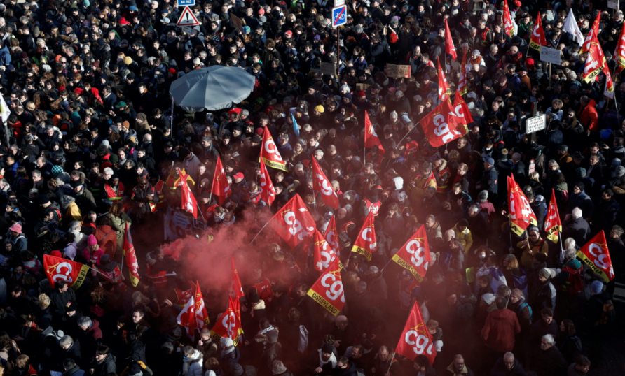 Manifestantes seguram bandeiras sindicais francesas da CGT enquanto se reúnem na Place d'Italie durante uma manifestação contra o plano de reforma previdenciária do governo francês em Paris, como parte de um dia de greve nacional e protestos na França, em 31 de janeiro de 2023