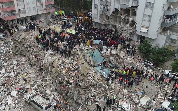 Pessoas se reúnem enquanto equipes de resgate procuram sobreviventes sob os escombros, após um terremoto, na cidade controlada por rebeldes de Jandaris, Síria, 6 de fevereiro de 2023