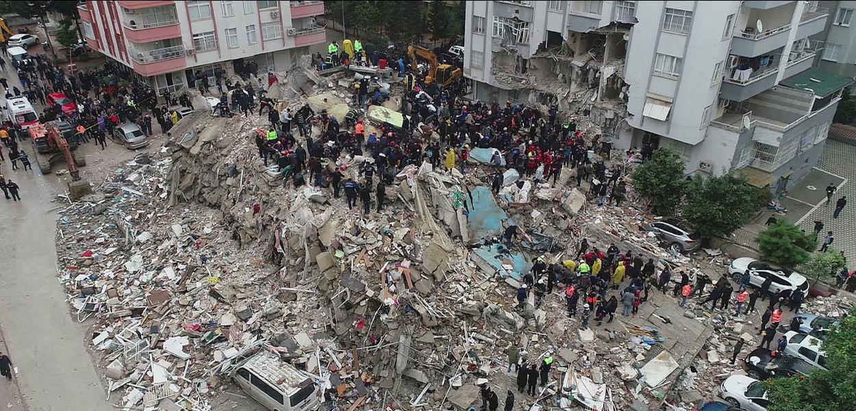 Pessoas se reúnem enquanto equipes de resgate procuram sobreviventes sob os escombros, após um terremoto, na cidade controlada por rebeldes de Jandaris, Síria, 6 de fevereiro de 2023