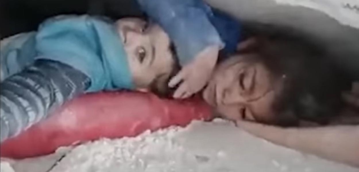 Menina síria protege o irmão em meio a escombros após terremoto de magnitude 7.8