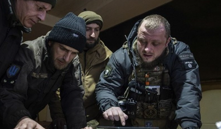 Um comandante ucraniano de uma unidade conhecida como "Kurt" (à direita) fala com seus colegas durante o planejamento da operação matinal na linha de frente na região de Donetsk, Ucrânia, segunda-feira, 13 de fevereiro de 2023