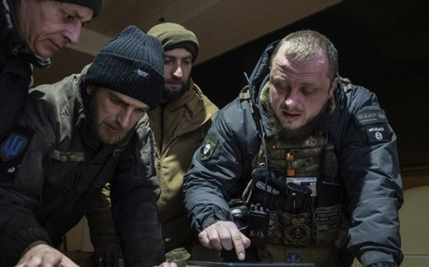 Um comandante ucraniano de uma unidade conhecida como "Kurt" (à direita) fala com seus colegas durante o planejamento da operação matinal na linha de frente na região de Donetsk, Ucrânia, segunda-feira, 13 de fevereiro de 2023