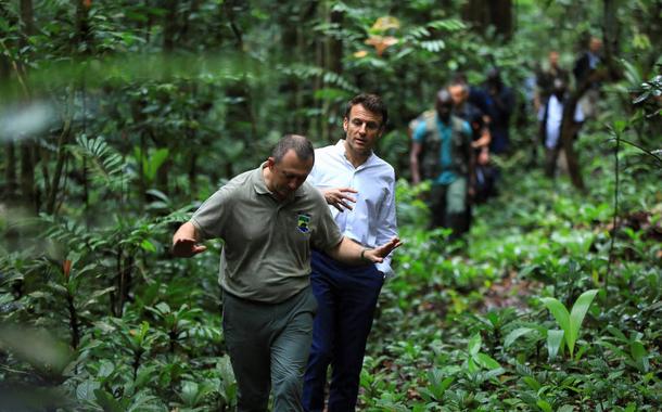 O presidente da França, Emmanuel Macron, caminha ao lado do ministro da Água e das Florestas do Gabão, Lee White, durante visita a área florestal da capital Libreville