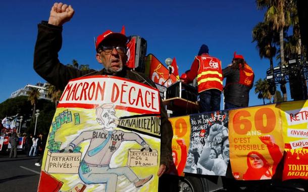Um sindicalista da CGT com um cartaz contra Emmanuel Macron durante uma das manifestações contra a reforma da aposentadoria