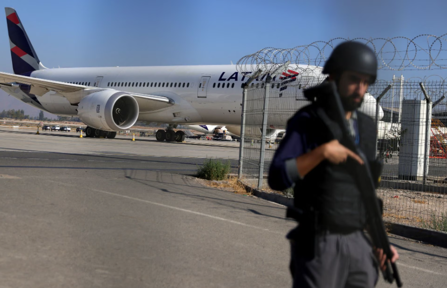 Um segurança vigia um acesso ao Aeroporto de Santiago do Chile depois que uma tentativa de roubo de um caminhão deixou duas pessoas mortas em meio a um intenso tiroteio. 8 de março de 2023.