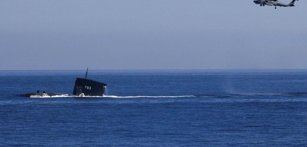 FILE PHOTO: A S70C helicopter can be seen flying around SS793 submarine as part of Taiwan's main annual "Han Kuang" exercises, as 20 naval vessels including frigates and destroyers fired shells to simulate intercepting and attacking an invading force, off Taiwan's northeastern coast, in Yilan, Taiwan, July 26, 2022. REUTERS/Ann Wang/File Photo