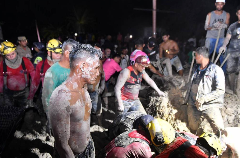 Pessoas sujas de lama, bombeiros e voluntários atuam no resgate de vítimas de desmoronamento em Manaus