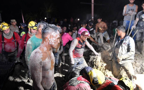 Pessoas sujas de lama, bombeiros e voluntários atuam no resgate de vítimas de desmoronamento em Manaus