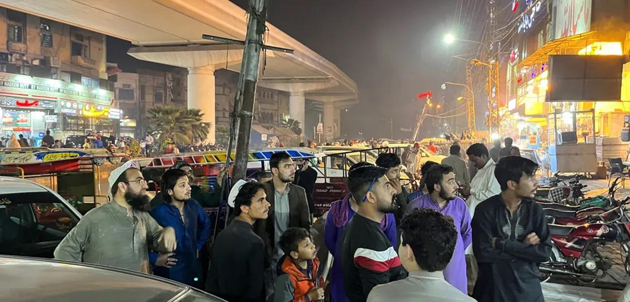 Pessoas aguardam do lado de fora de um restaurante depois que um tremor foi sentido em Lahore, Paquistão
