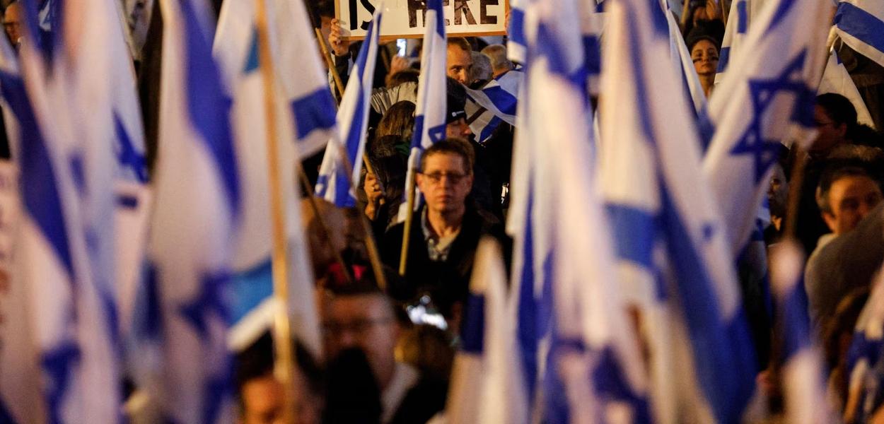 Israelenses protestam contra a nova coalizão de direita do primeiro-ministro Benjamin Netanyahu e suas reformas judiciais propostas para reduzir os poderes da Suprema Corte em uma praça principal em Tel Aviv, Israel