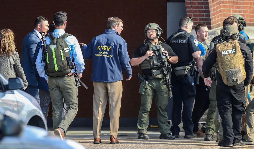 O governador de Kentucky, Andy Beshear, fala com a polícia destacada no local de um tiroteio em massa perto do estádio de beisebol Slugger Field, no centro de Louisville, Kentucky, EUA, 10 de abril de 2023