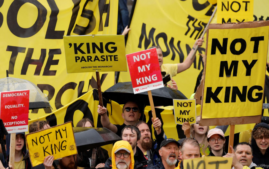 Manifestantes seguram cartazes enquanto as pessoas se reúnem no dia da cerimônia de coroação do rei Charles e da rainha Camilla, em Londres, Grã-Bretanha, 6 de maio de 2023 (Foto: REUTERS/Piroschka van de Wouw/Pool) Manifestantes seguram cartazes enquanto as pessoas se reúnem no dia da cerimônia de coroação do rei Charles e da rainha Camilla, em Londres, Grã-Bretanha, 6 de maio de 2023