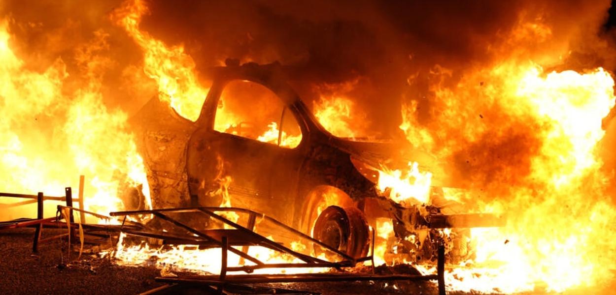 Um veículo é queimado, destruído por manifestantes em Nanterre, a oeste de Paris, em 27 de junho de 2023, depois que a polícia francesa matou um adolescente que se recusou a parar para uma fiscalização de trânsito na cidade.